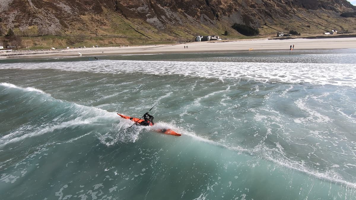 Surf kayaking on a wave towards the beach in Hoddevik