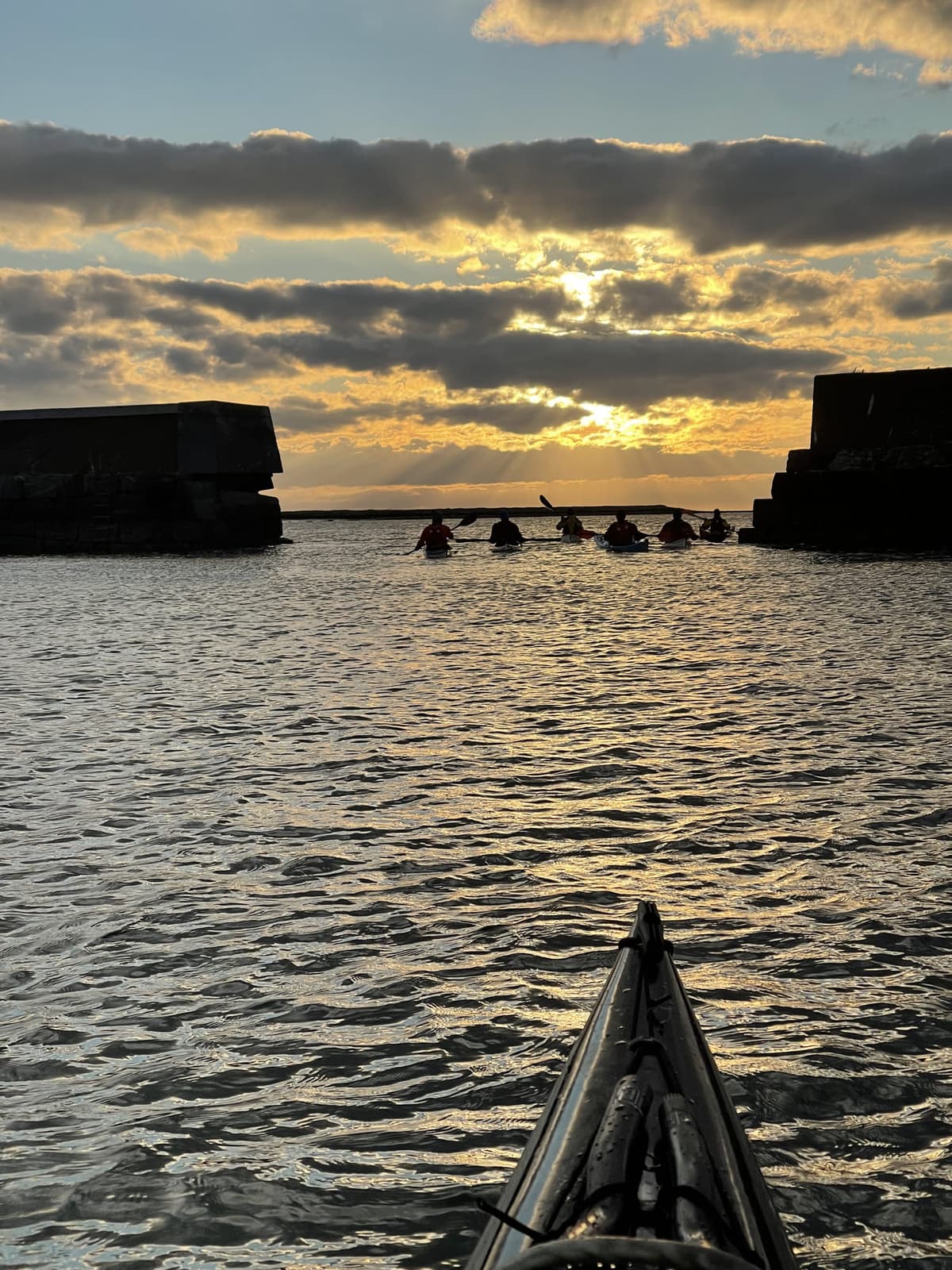 Evening paddling towards sunset by the breakwater